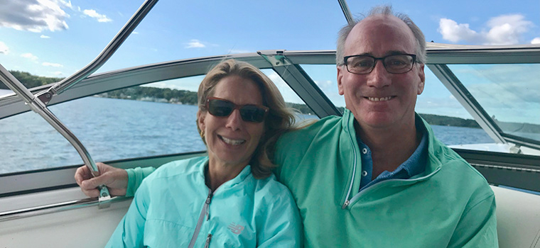 MSK Giving donor Samantha and her late husband, Rich, seated on a boat. Rich has his arm around Samantha, and they are both smiling.