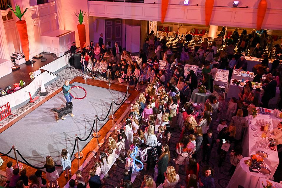 Attendees of The Society of MSK’s annual Bunny Hop fundraiser for pediatric cancer research at MSK Kids take in a dog-and-hoop performance. 