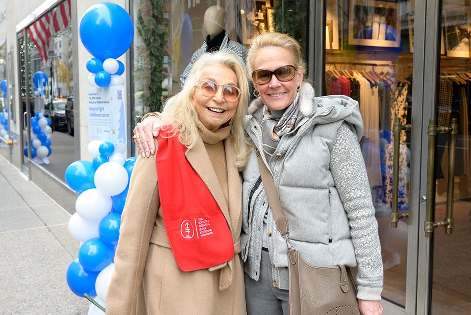 Two Society members smile by an NYC store at the annual Miracle on Madison event, which supports pediatric cancer research and care at MSK. 